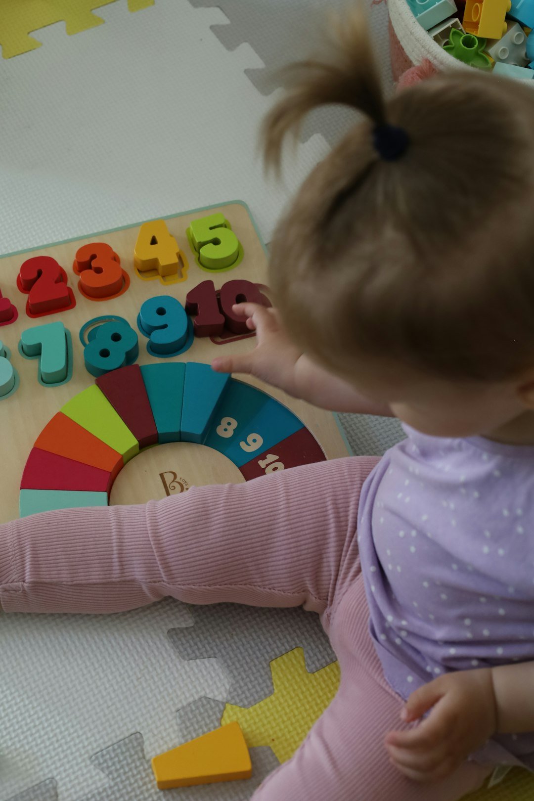 a-little-girl-playing-with-a-wooden-toy-o0pdixoftyc
